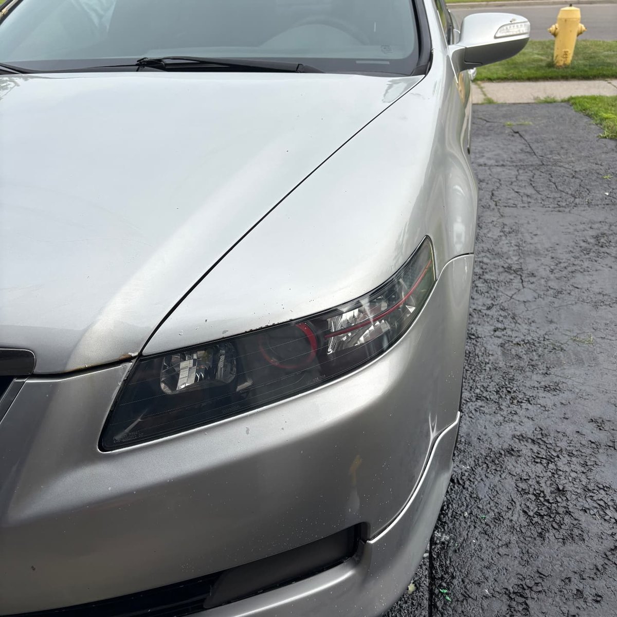 Clear polished headlight on a silver Acura TL after restoration