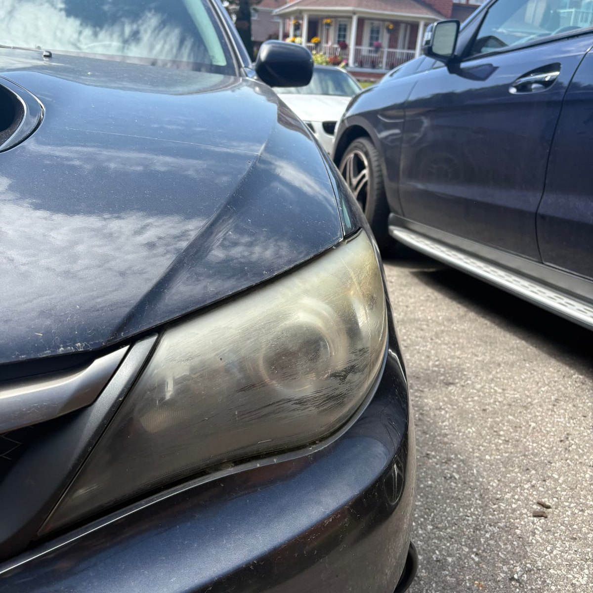 Oxidized passenger side headlight on a grey Subaru WRX before restoration