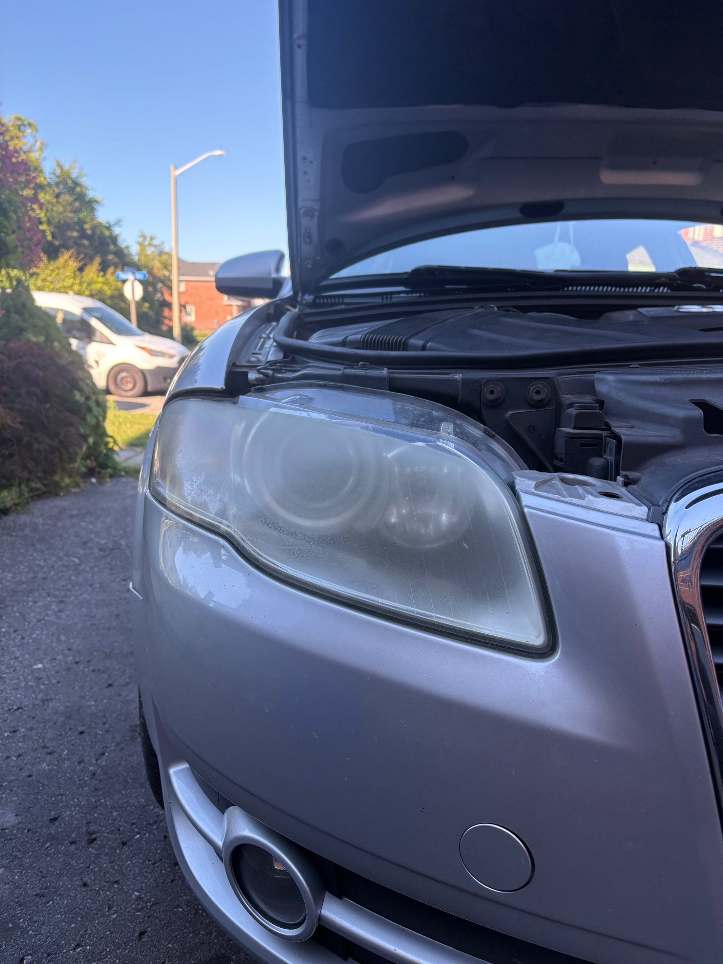 Yellowed, hazy oxidized headlight on a silver Audi A4 before restoration